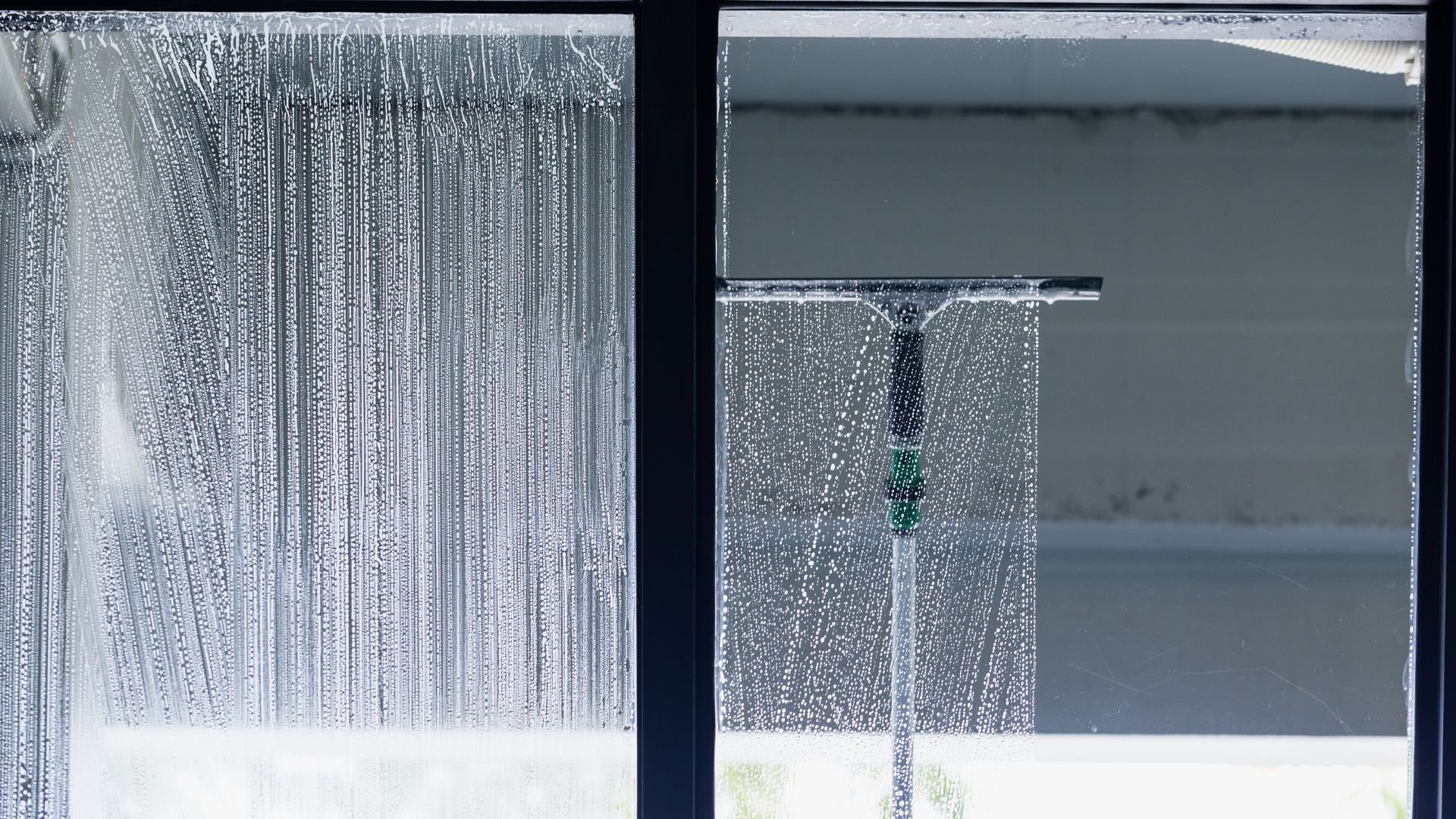 Condensation on window with water droplets running down glass panes